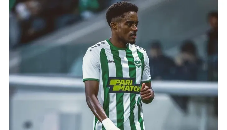 Jogador com camisa listrada verde e branca patrocinada pela Parimatch em jogo da Chipre Primeira Divisão