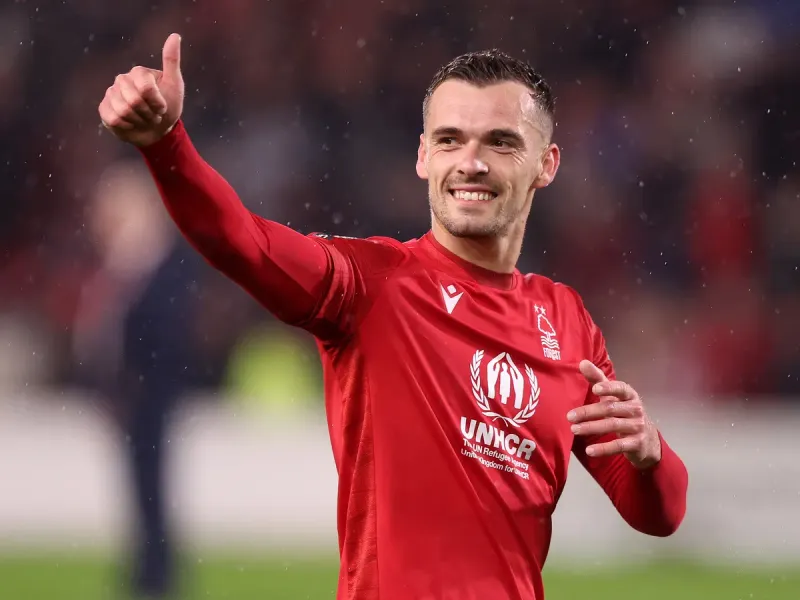 Harry Toffolo sorrindo e fazendo sinal de positivo com a camisa vermelha do Nottingham Forest