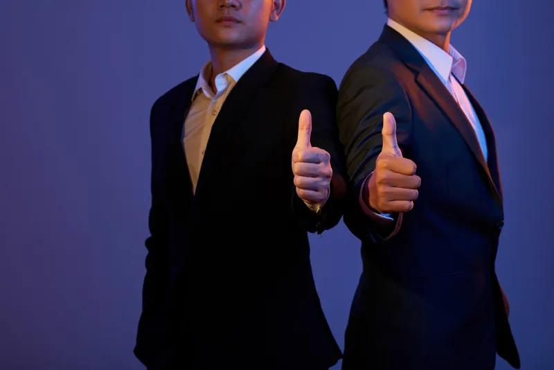 Dois homens de terno fazendo sinal de positivo, análise que avalia se a SSSGame é confiável